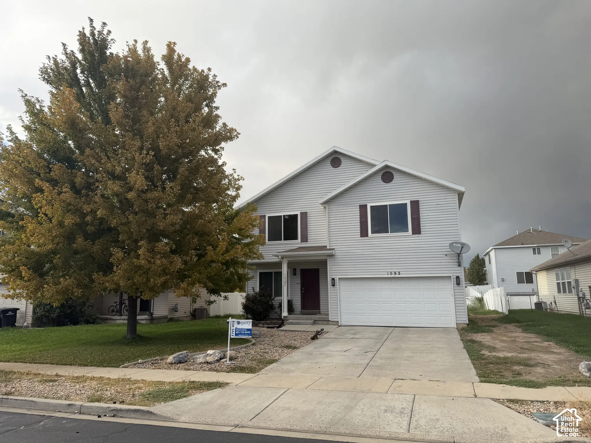 Two-story residence with light-colored siding, a two-car garage, and a concrete driveway
