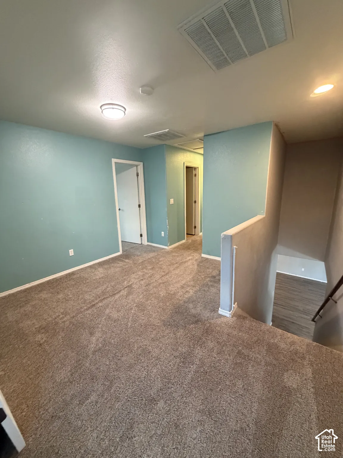 Carpeted room with light blue walls, white trim, and a flush-mount ceiling light