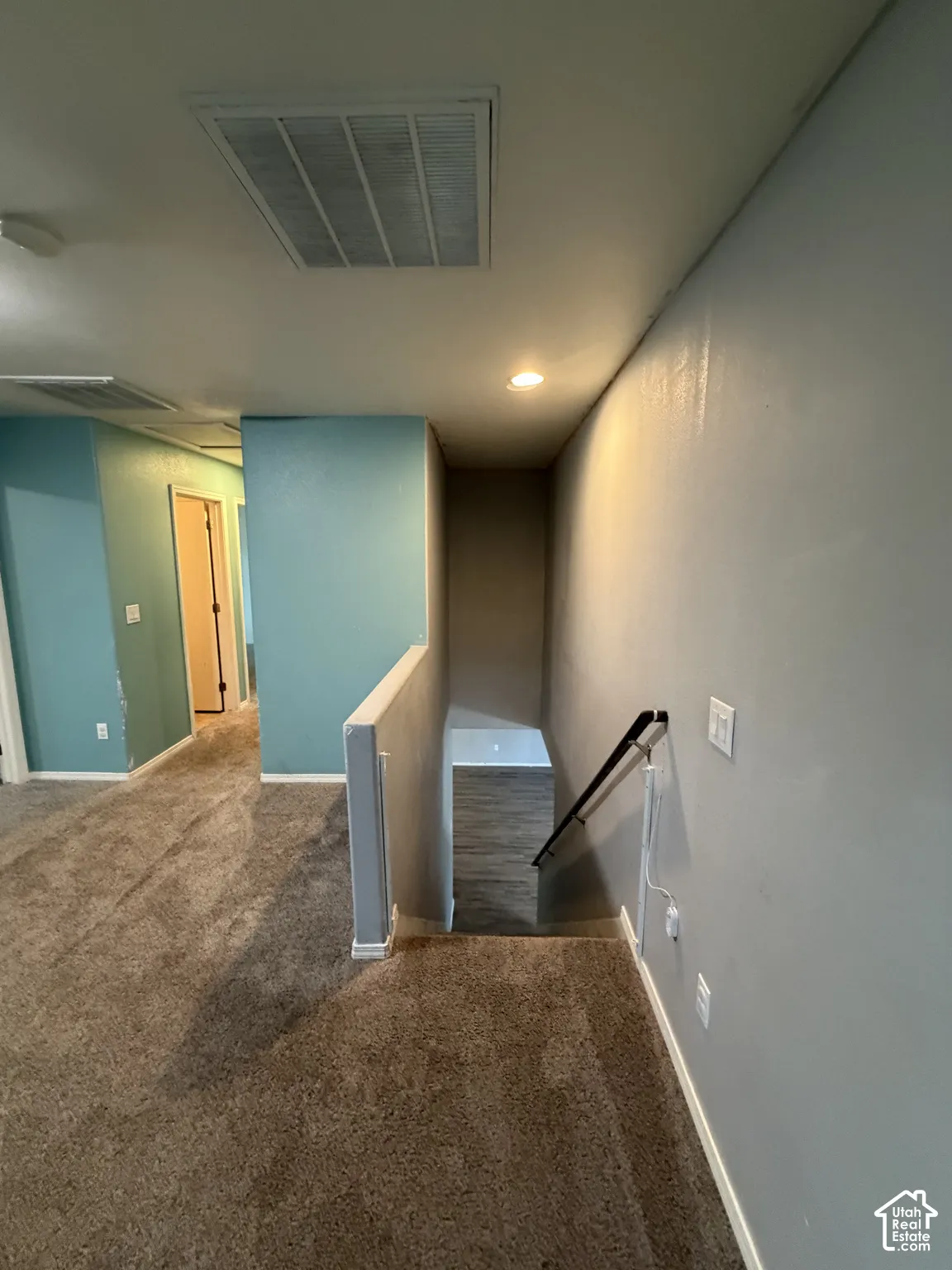Plush carpeting throughout, recessed ceiling lighting, and a white ceiling vent