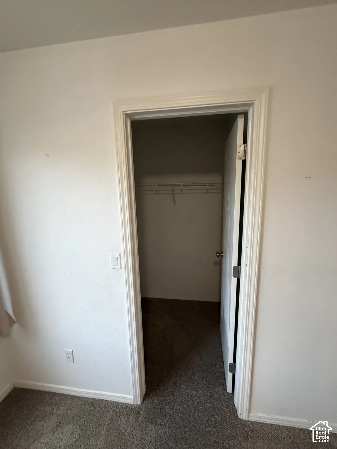 Carpeted room with a closet featuring a wire shelving system