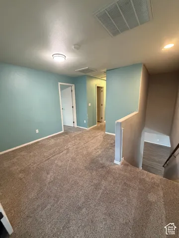 Carpeted room with light blue walls, white trim, and a flush-mount ceiling light