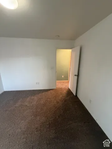 Neutral-toned carpeting, white painted walls, and a flush mount ceiling light fixture