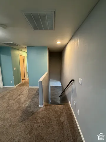 Plush carpeting throughout, recessed ceiling lighting, and a white ceiling vent