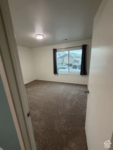 Neutral wall paint, brown carpet flooring, and a flush-mount ceiling light fixture