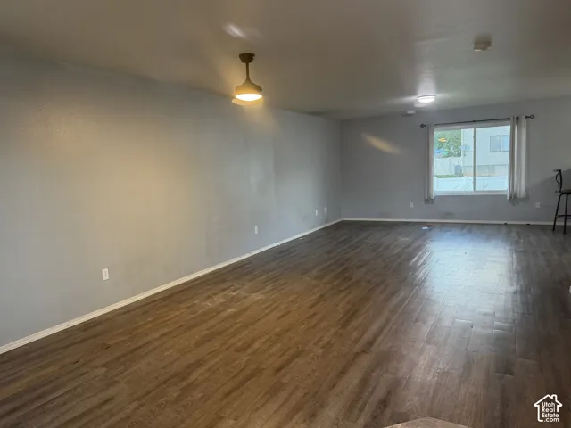 Expansive room featuring wood-finish flooring, light gray walls, and a large window