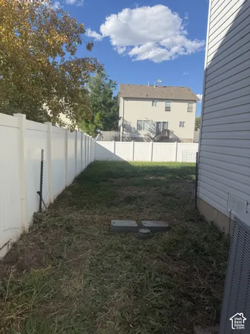 Enclosed backyard featuring a white privacy fence.