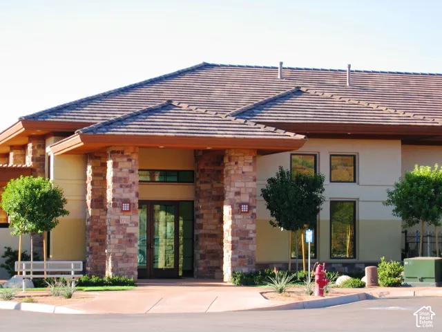 Stone-clad entry columns with expansive glass doors and transom windows