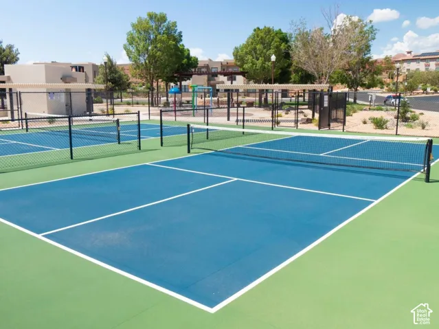 Outdoor pickleball courts with perimeter fencing and a designated recreational area