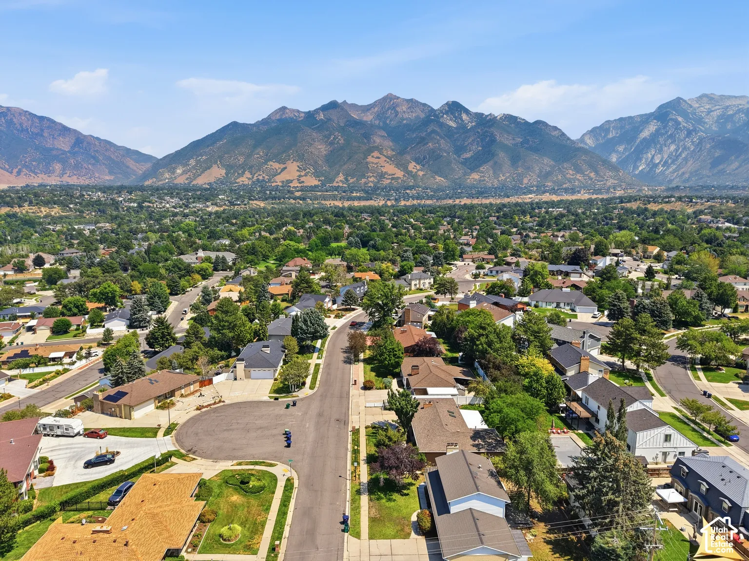 Expansive mountainous scenery, mature tree canopy, and residential area