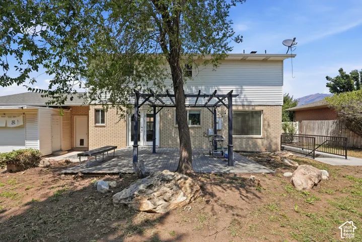 Brick and horizontal siding exterior with a ground-level wood deck