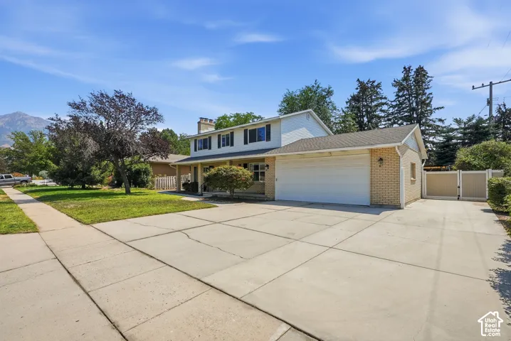 Two-story residence with a prominent two-car garage, expansive concrete driveway, and a front porch