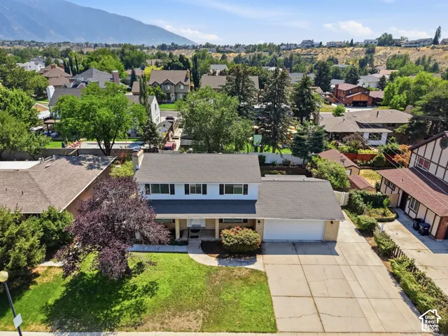 Traditional two-story residence with a two-car garage, mature landscaping, and a paved driveway