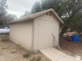 Detached utility structure with a gabled roof and a concrete access ramp
