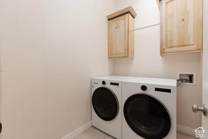 Laundry area featuring light-toned cabinetry and a hanging rod
