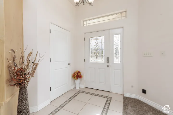 Entryway featuring a decorative transom window, an ornate stained-glass front door, and a sidelight with stained-glass details