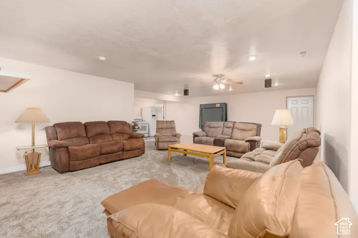 Carpeted room with recessed lighting, ceiling fan, and a built-in wall speaker system
