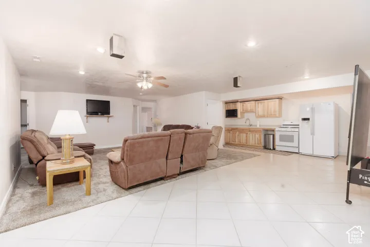 Kitchen/dining with recessed lighting, ceiling fan, and tile flooring complement the wood-finish cabinetry and white appliances