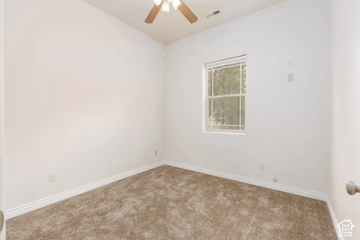 Bedroom 3 with neutral-toned wall-to-wall carpeting complements the light wall color