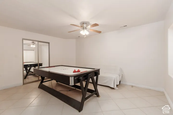Bedroom 6 with ceramic tile flooring, mirrored closet doors, and a ceiling fan