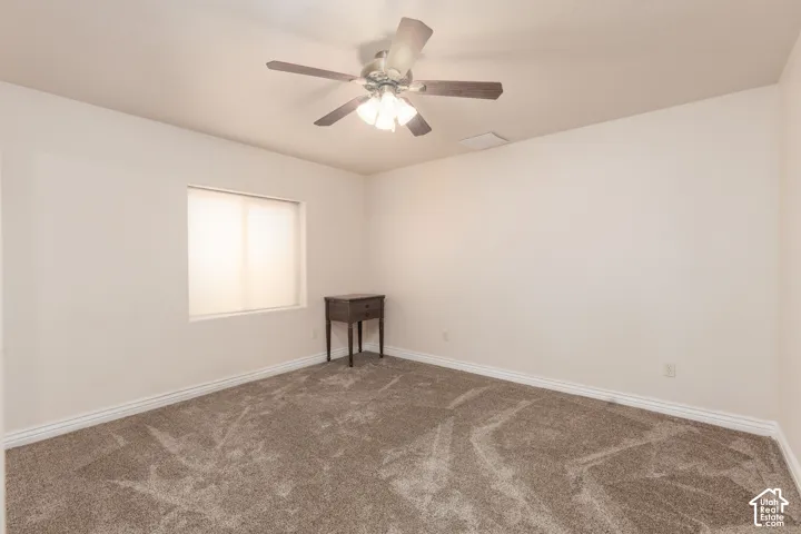 Bedroom 4 with white walls, light-filtering window shades, and a ceiling fan with light fixture