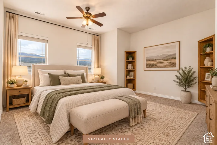 Primary bedroom with vaulted ceiling with a ceiling fan, two windows, wall-to-wall carpeting, and two built-in wooden bookshelves