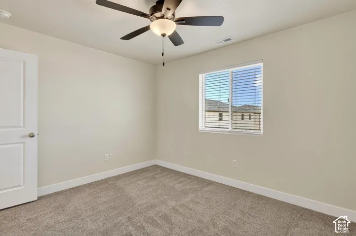 Neutral wall color, window with horizontal blinds, ceiling fan with integrated lighting, and wall-to-wall carpeting