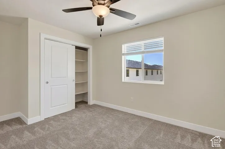 Neutral wall tones with a ceiling fan, window with blinds, and white trim