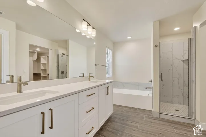 Dual vanity with white shaker cabinetry and brass hardware, undermount sinks, and a large mirror