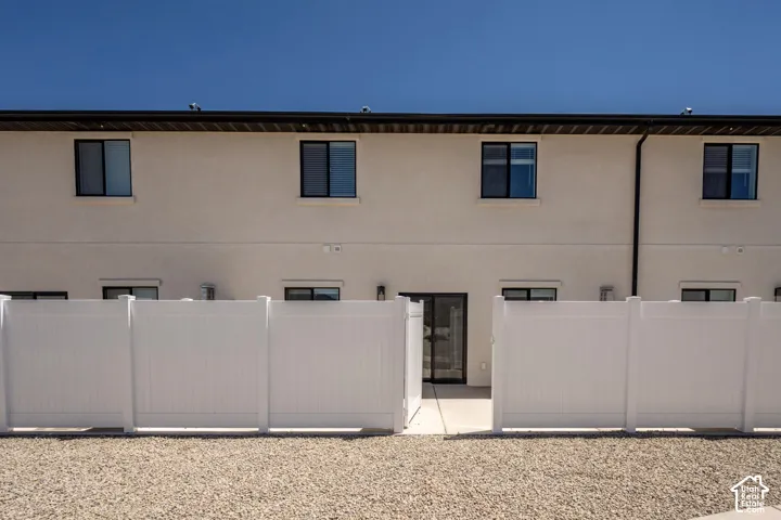 Two-story exterior with stucco finish and dark-framed windows