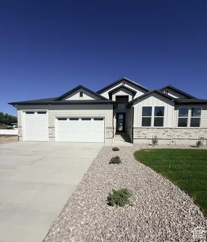 Contemporary exterior with a multi-textured facade featuring stone accents, a multi-car garage, and a concrete driveway