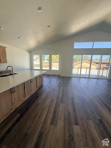 Open-concept living area featuring a vaulted ceiling and recessed lighting