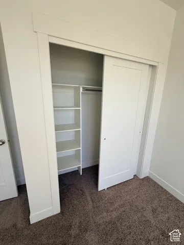 Closet featuring white sliding doors, built-in shelving, and a hanging rod