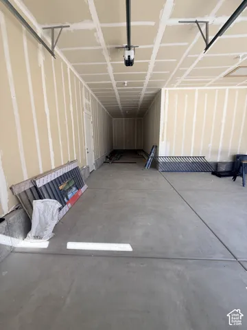 Spacious garage featuring a concrete floor, high ceilings, and an automatic garage door opener
