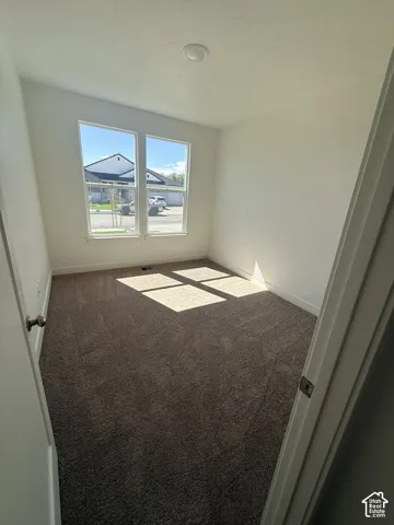 Neutral wall paint, brown carpet flooring, and a flush mount ceiling light