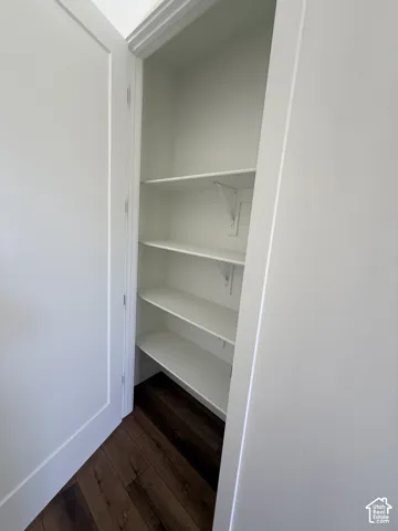 Built-in shelving with white finishes and dark wood-finish flooring
