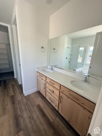 Dual vanity with light wood-finish cabinetry and white countertops