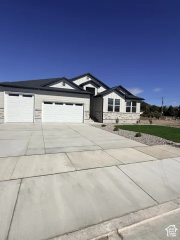 Contemporary exterior with light siding and stone accents, a dual-bay garage, a separate single-bay garage, and a concrete driveway