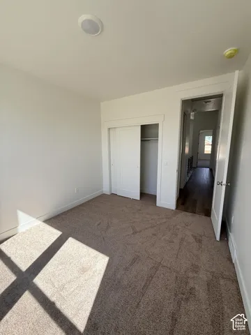 Neutral wall paint, recessed lighting, white trim, sliding closet doors, and carpet flooring