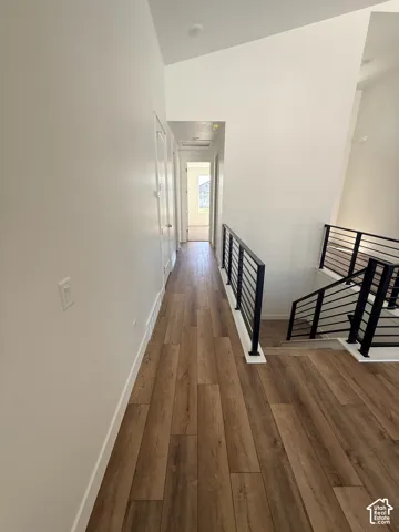 Vaulted ceilings, wood-finish flooring, and contemporary horizontal metal railings with white posts