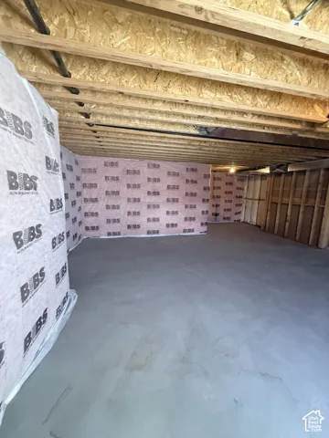 Unfinished basement featuring exposed wood joists, structural framing, and concrete flooring