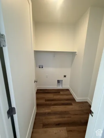 Utility room featuring wood-finish flooring, a bright overhead light, and a built-in shelf