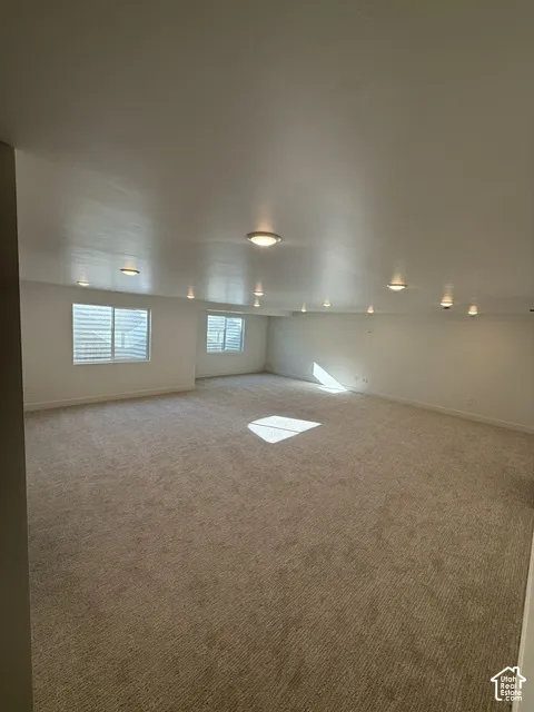 Recessed ceiling lighting, flush-mount ceiling lighting, neutral carpet flooring, multiple windows, and white window blinds