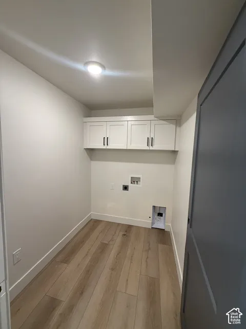 Recessed ceiling lighting, wood-finish flooring, and white cabinetry