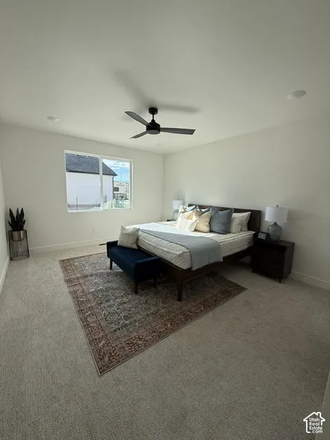 Light-colored carpeted flooring, white painted walls, black ceiling fan with integrated lighting, recessed lighting, and a large window
