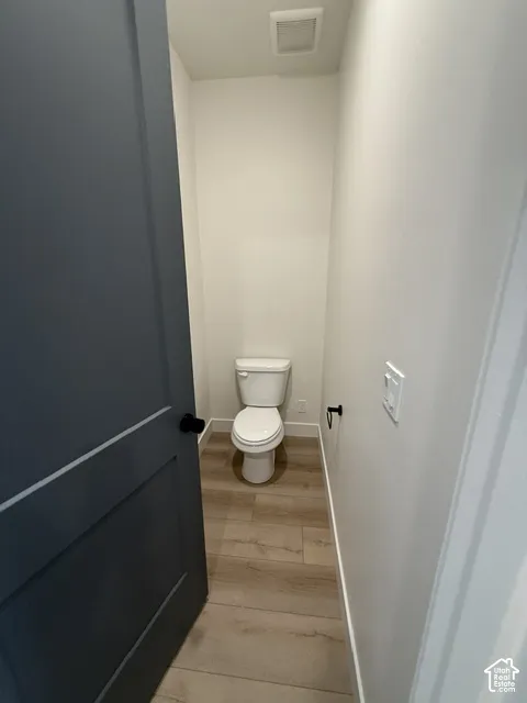 Recessed lighting, wood-finish flooring, and white walls