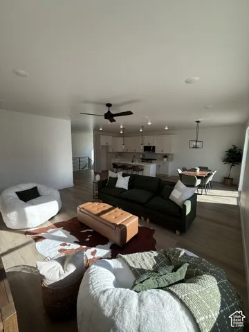 Open-concept living area featuring wood-finish flooring, recessed lighting, and a contemporary ceiling fan