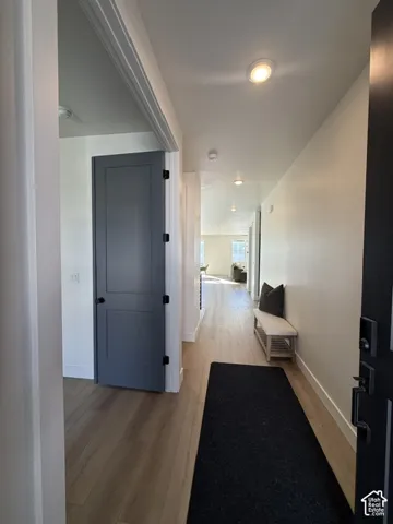 Recessed ceiling lighting, wood-finish flooring, and a solid core interior door with matte black hardware