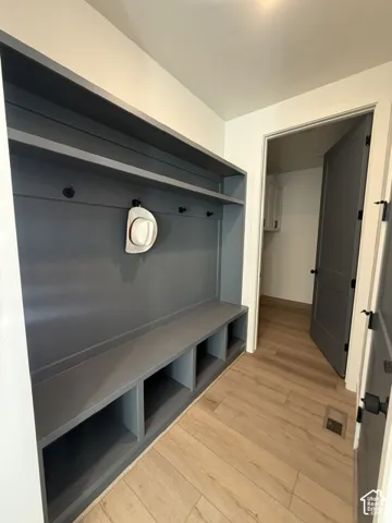 Built-in storage bench with open cubbies, integrated shelving, and hanging hooks