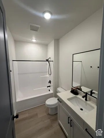 Bathroom featuring white vanity with stone-finish countertop, undermount sink, and matte black hardware
