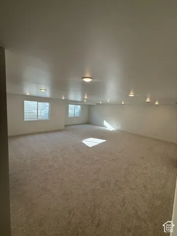 Recessed ceiling lighting, flush-mount ceiling lighting, neutral carpet flooring, multiple windows, and white window blinds